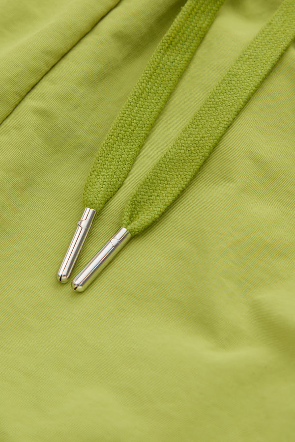 Close-up of green  drawstring with metal eyelets on a green fabric shorts