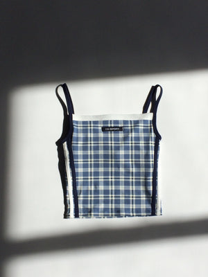Plaid-patterned tank top with black trim on a white background