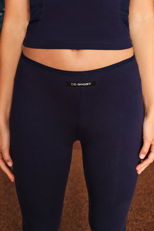 Close-up of a person wearing dark navy leggings with a small black waistband label reading 'DB SPORT'.
|M1