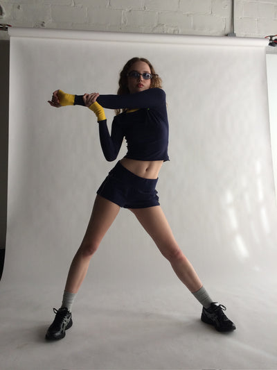 Person posing in a studio setting with a white backdrop  |M1