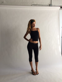 Woman wearing a black athletic outfit standing against a white background  |M1