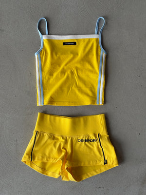 Yellow tank top and shorts set with visible branding on a gray background
