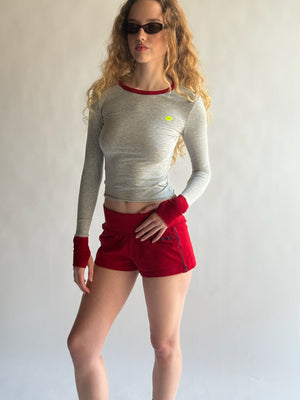 Person wearing a gray long-sleeve top and red shorts with a white background  |M1