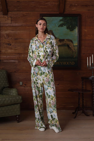 Long-sleeve pajama set with dark piping in a green, pink, yellow and blue floral print on white, shown on a model, front view. |M2